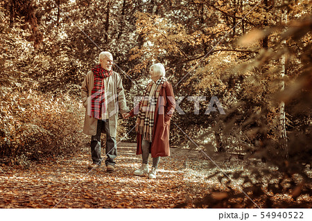 Senior woman and man walking together in a park. 54940522