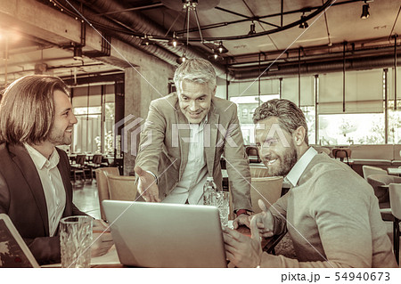 Positive delighted worker pointing at screen of laptop Positive delighted worker pointing at screen of laptop 54940673
