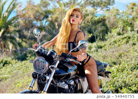Sexy woman posing on motorcycle outdoors Sexy woman posing on motorcycle outdoors 54940755