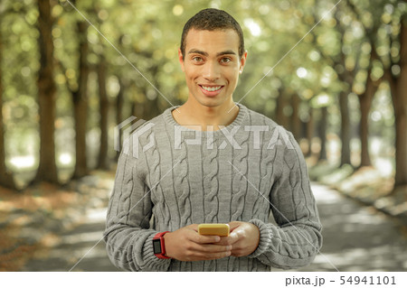 Cheerful young man spending sunny day outside 54941101
