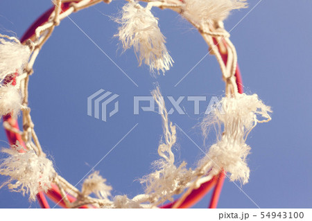 Red basketball hoop against a blue sky 54943100