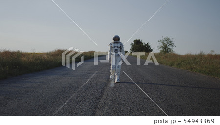 Astronaut walking on road Astronaut walking on road 54943369
