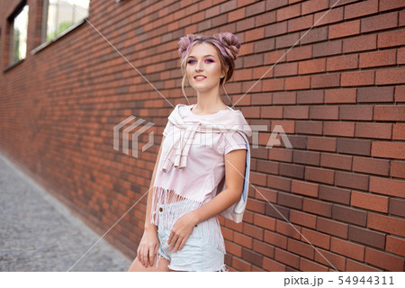 Beautiful smiling woman with clear skin, bright pink make-up and white teeth with hair bun on a red Beautiful smiling woman with clear skin, bright pink make-up and white teeth with hair bun on a red 54944311