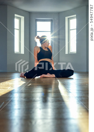 Morning yoga girl doing stretching exercises in the room for Pilates. Beautiful light, air photos, a 54947787