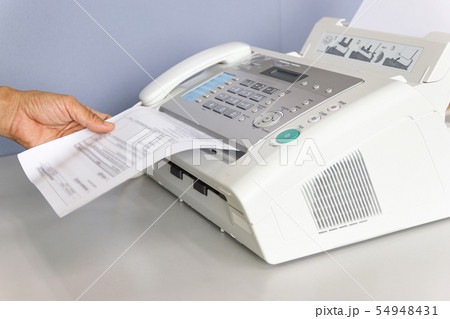 hand man are using a fax machine in the office 54948431