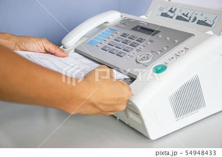hand man are using a fax machine in the office 54948433