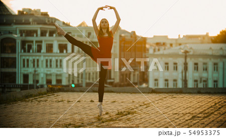 Young woman ballerina training on the roof - standing on her tiptoe in the pointe shoes and Young woman ballerina training on the roof - standing on her tiptoe in the pointe shoes and 54953375