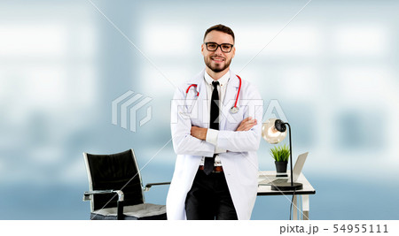 Handsome doctor standing in hospital office. 54955111