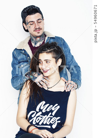 Young couple together. guy with tattoo, girlfriend wearing dreadlocks having fun on white background Young couple together. guy with tattoo, girlfriend wearing dreadlocks having fun on white background 54960671