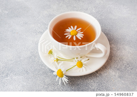 cup of herbal tea with chamomile flowers on grey  54960837
