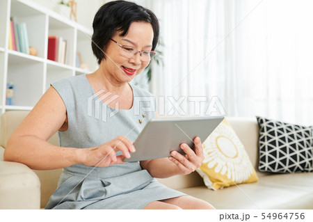 Woman using tablet pc at home Woman using tablet pc at home 54964756