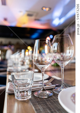 Wine glasses in the foreground. Wedding Banquet or gala dinner. The chairs and table for guests 54973266