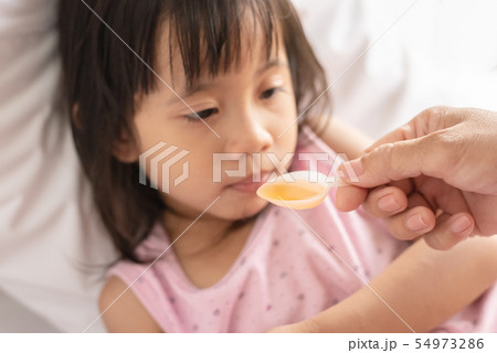 Unhappy asain girl when taking medicine syrup from Unhappy asain girl when taking medicine syrup from 54973286