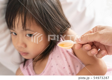 Unhappy asain girl when taking medicine syrup from Unhappy asain girl when taking medicine syrup from 54973287