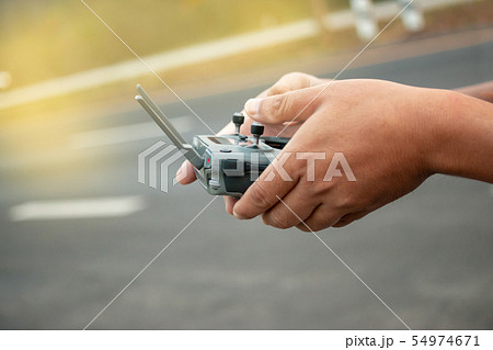 hands with remote controller of drone outside. hands with remote controller of drone outside. 54974671