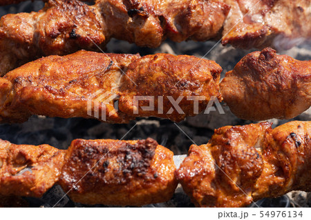 Grilled pork shish kebab cooking on skewers grill 54976134