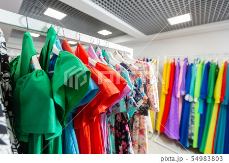 Cocktail dress. Clothing on hanger at the modern shop boutique. Bright multi-colored fabrics 54983803
