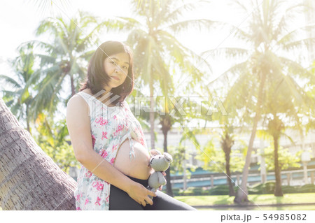 Young happy pregnant women relaxing with doll in Young happy pregnant women relaxing with doll in 54985082