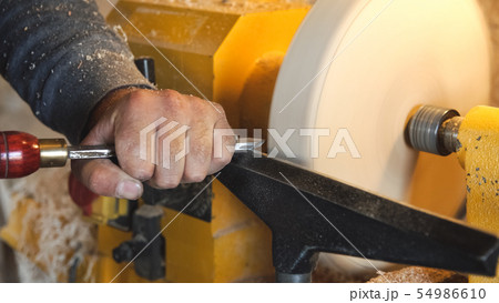 Craftsman works with workpiece in workshop. Craftsman works with workpiece in workshop. 54986610