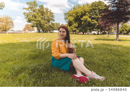 Young woman in a yellow jacket and green skirt 54986840