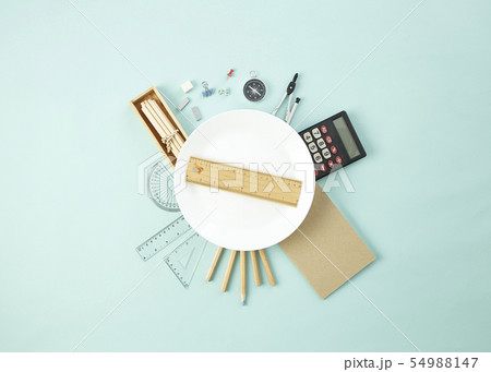 School supplies around the empty white dish School supplies around the empty white dish 54988147
