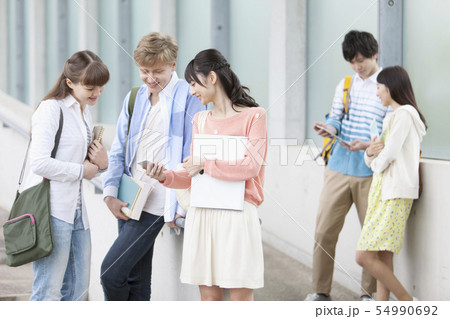 スマートフォンを見る大学生男女 スマートフォンを見る大学生男女 54990692