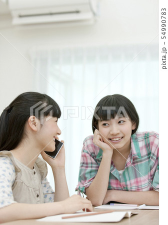 スマートフォンで通話する女の子と友達 54990783