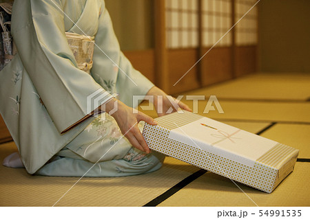 贈答品を差し出す着物姿の女性 贈答品を差し出す着物姿の女性 54991535
