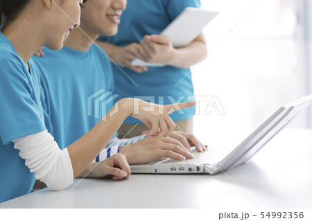 ノートパソコンを見て話す男女の手元 54992356