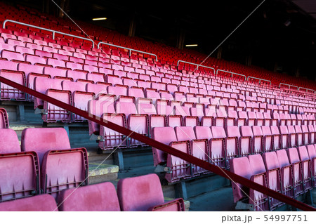 Vacant red chairs of stadium stand 54997751