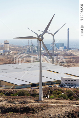 White turbines at wind farm with power station 54998856