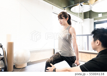 トレーニングジムで下半身を鍛える女性（ダンベルで重しをつける） 55004138
