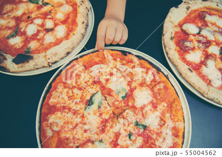 High angle shot of unrecognizable people's hand grabbing a slice of pizza 55004562