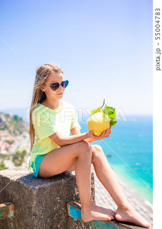 Big yellow lemon in hand in background of mediterranean sea and sky. 55004783