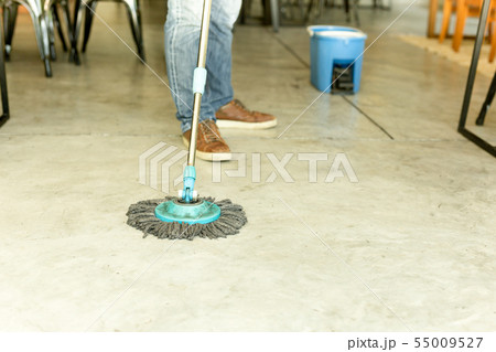 Man worker with mop and bucket cleaning floor in the cafe. Man worker with mop and bucket cleaning floor in the cafe. 55009527