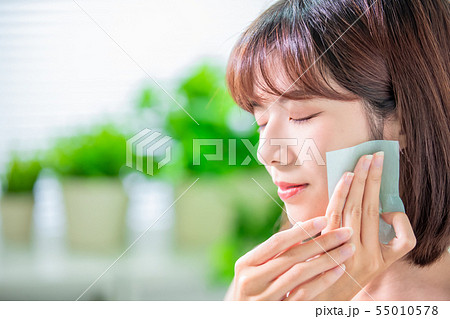 woman use oil blotting paper 55010578