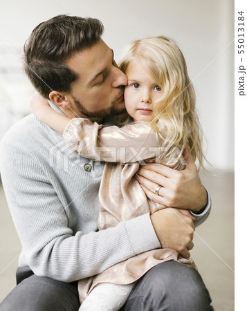 Mid adult man kissing his daughter on the cheek Mid adult man kissing his daughter on the cheek 55013184