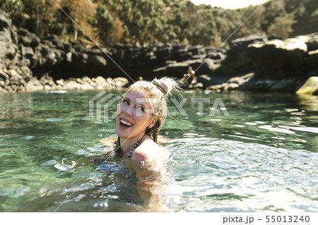 Smiling woman swimming in sea 55013240