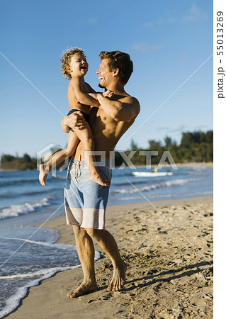 Man playing with his son on beach 55013269