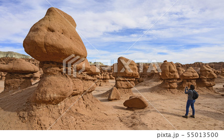 Woman photographing hoodoos in Goblin Valley State Park, Utah, USA 55013500