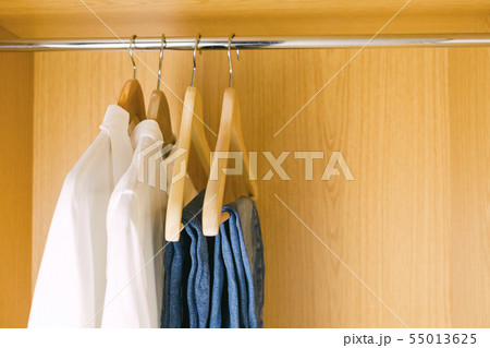 Clothes hanging in wardrobe 55013625