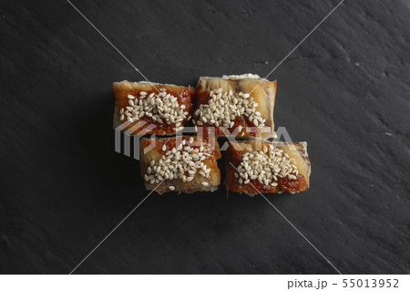 Sushi with sesame seeds on black surface 55013952
