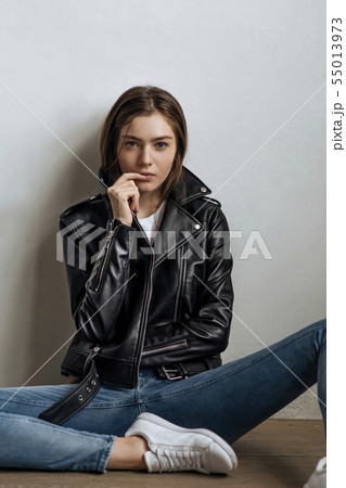 Young woman wearing black leather jacket 55013973