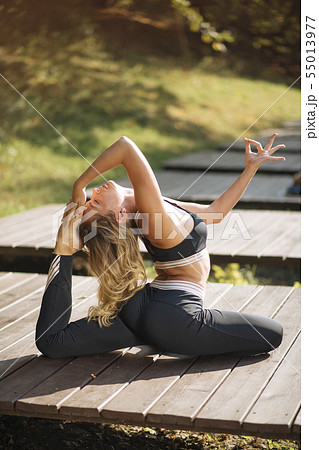 Young woman practicing yoga on boardwalk Young woman practicing yoga on boardwalk 55013977