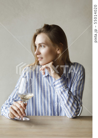 Young woman with glass of white wine Young woman with glass of white wine 55014020