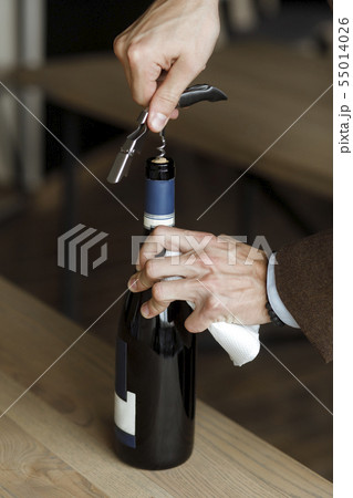 Hands of man opening bottle of wine Hands of man opening bottle of wine 55014026