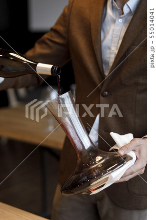 Waiter pouring red wine into decanter Waiter pouring red wine into decanter 55014041