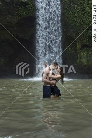 Young couple embracing in river by Tibumana Waterfall in Bali, Indonesia 55014238