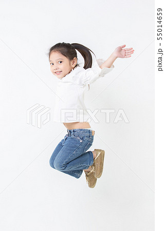 Smiling little Asian girl jumping on white 55014659