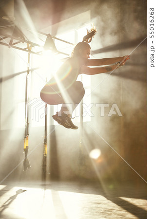 Higher and higher. Side view of young athletic woman in sport clothing jumping while exercising in Higher and higher. Side view of young athletic woman in sport clothing jumping while exercising in 55016268